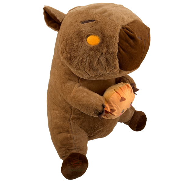 Sitzendes Capybara Plüschtier XXL ca. 80 cm in Braun mit dunkler Schnauze, das einen Cookie in den Pfoten hält.